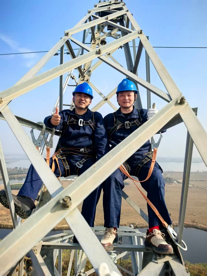 退役军人学员完成登高技能实操后，在塔上露出自信笑容、比出大拇指。