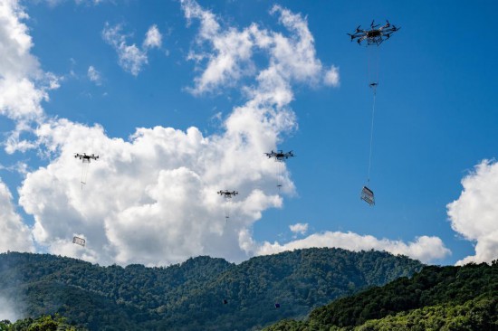 中老500千伏联网工程在施工过程中运用无人机集群作业方式开展施工物资运输。（张强 摄）