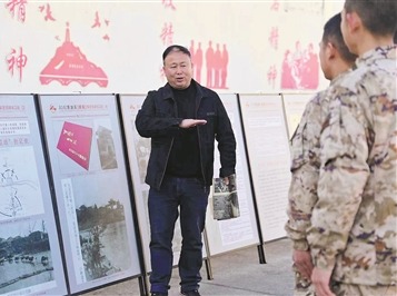 影像展现场,李森亮在“烽火岁月”展区的抗战影像史料展板前,为官兵讲述侵华日军的残暴行径。殷 超摄