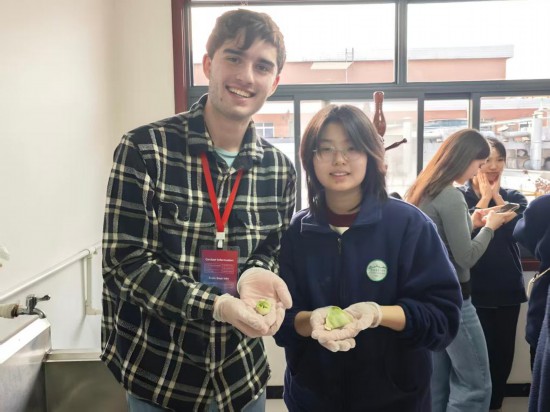 　　2025年12月30日，美国艾奥瓦州青少年“友谊传承”研学团成员菲尼安·哈金斯和中国伙伴一起展示刚包好的饺子。新华社记者 董笑坤 摄