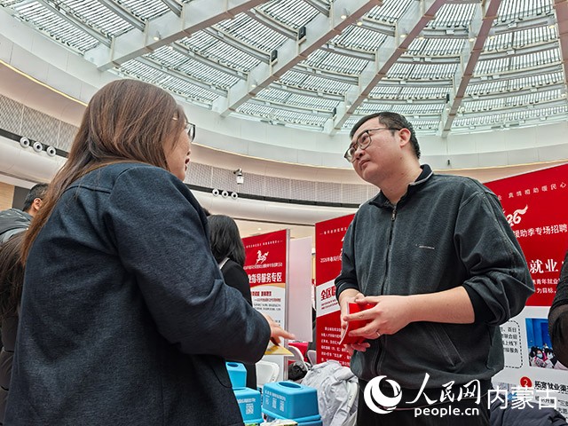 工作人员向求职者解读就业政策。实习生 赵爽摄