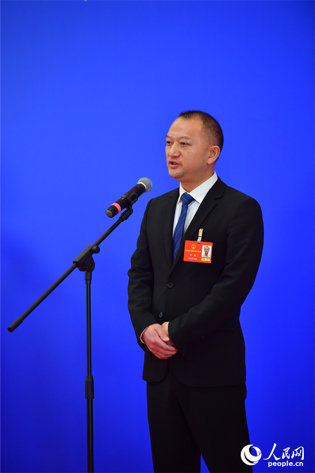 江西省人大代表、比亚迪集团江西省总经理，总裁办行政部总监邓鹏在“代表通道”上接受采访。人民网记者 时雨摄