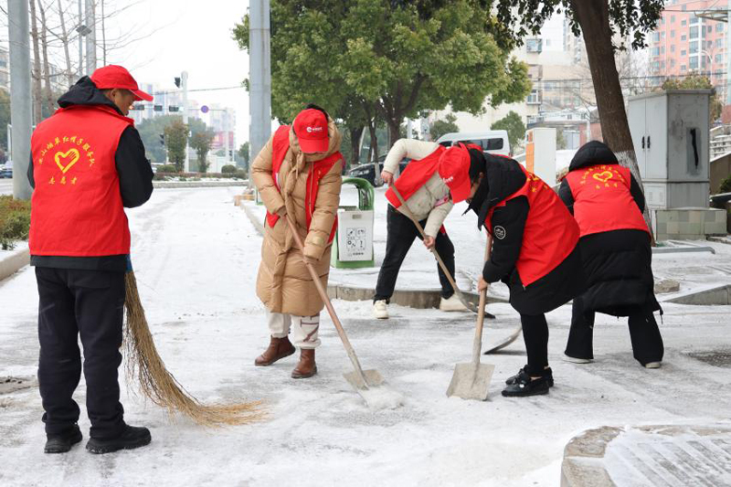 “红帽子”志愿服务队在街头扫雪除冰。