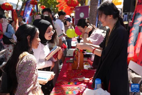 2月1日，人们在南非开普敦维多利亚港区举行的中国年庆祝活动上学习制作中国绳结。新华社记者 王雷 摄