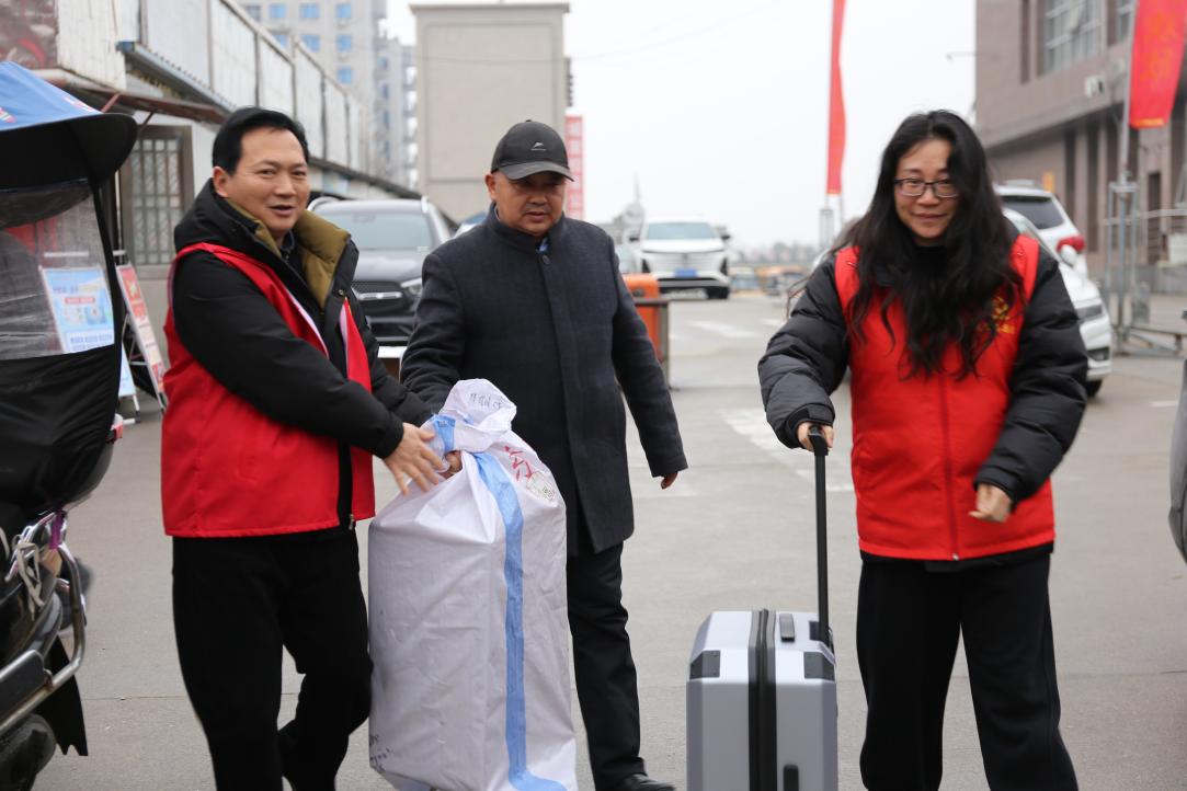 党员志愿者助力返乡务工人员搬运行李