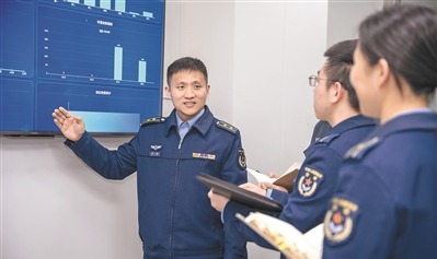 该旅工程师刘璐（左一）为系统研发小组新成员讲解系统设计原理。徐浩钧摄