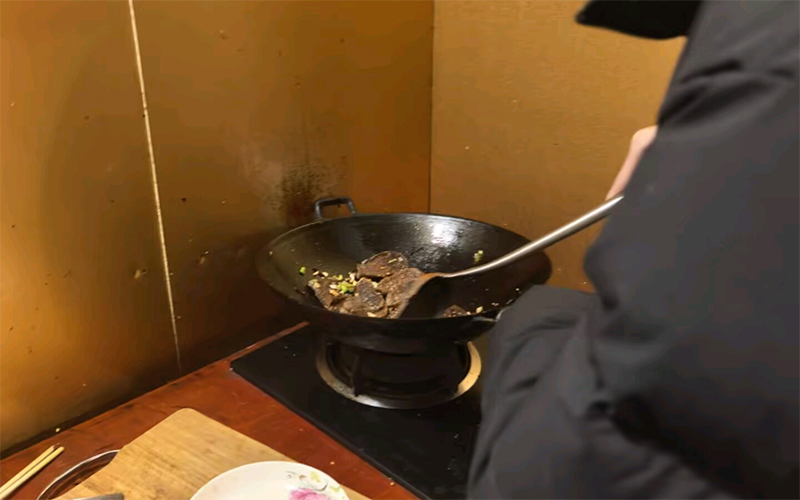 学生龚佑奥正在炒菜。