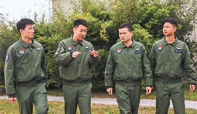 一位副政治教导员(左二)与飞行员交流谈心。李希鑫、兰尔文摄