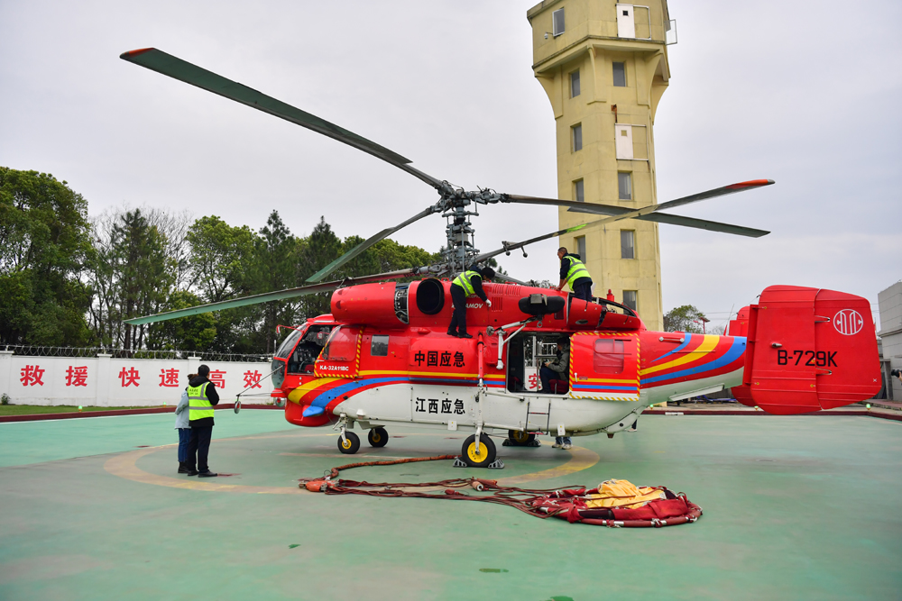 江西省航空护林局南昌基地停机坪上的直升机，机务人员正在对其进行保养维护。人民网记者 时雨摄